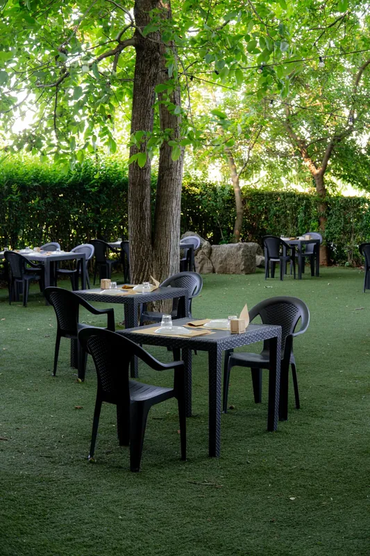 Tavoli immersi nel verde del giardino della Baracca