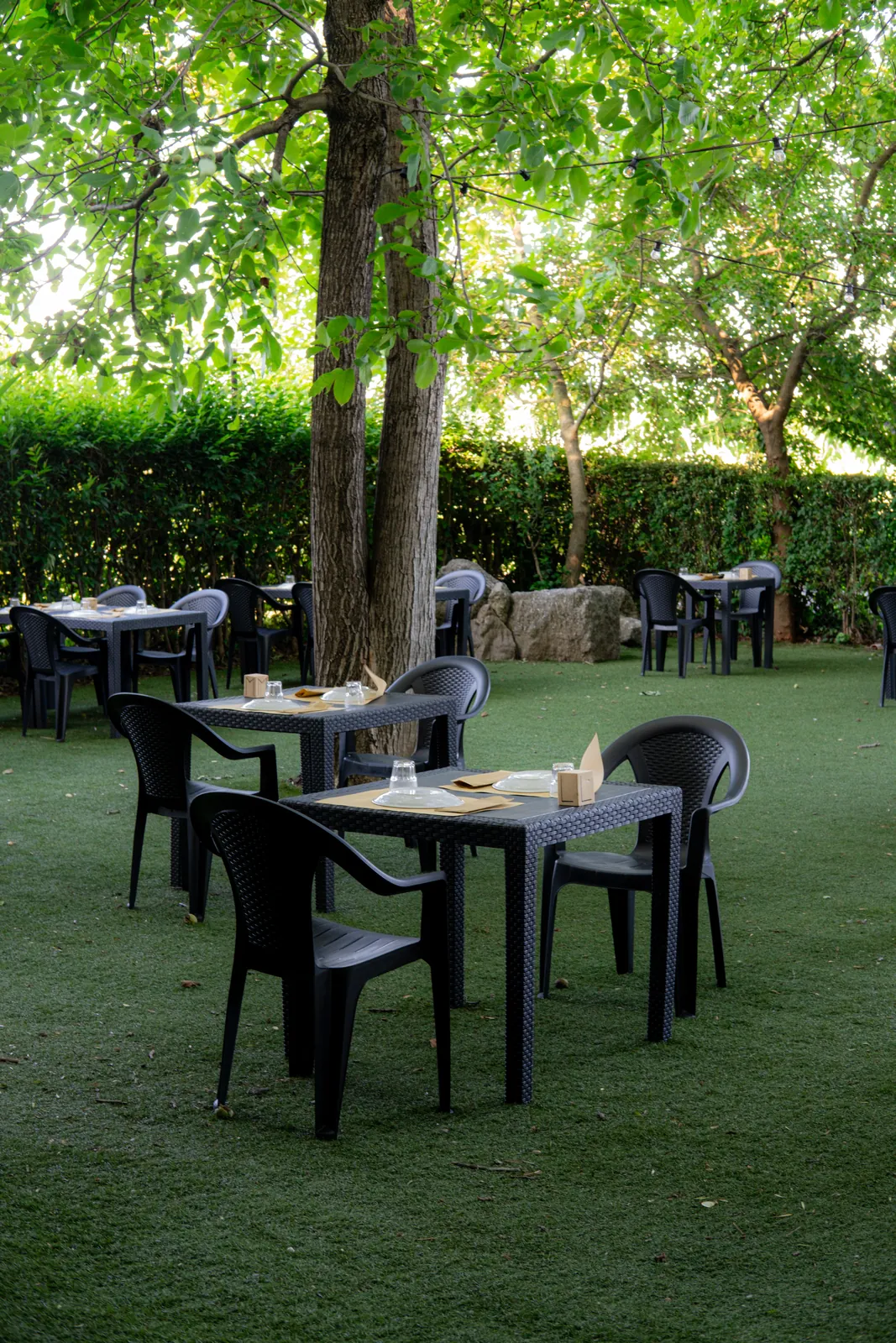Tavoli immersi nel verde del giardino della Baracca